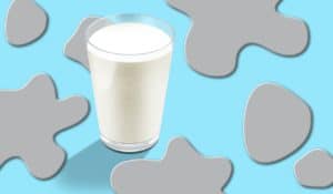 Glass of milk against a blue and gray background.