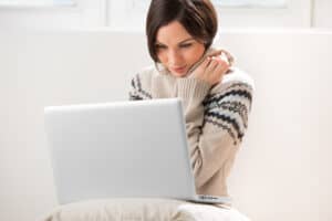 Young woman sitting on the floor in front of her laptop