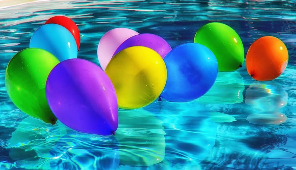 Several colorful balloons floating on water
