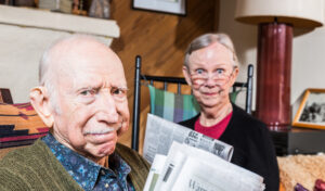 Elderly man and woman with expressions of annoyance on their faces.