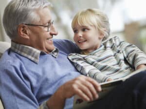 Grandpa reading a book to little girl