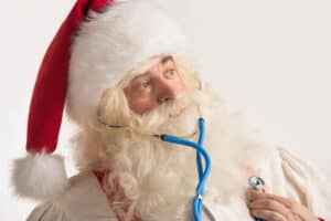 Santa Claus listening to his heartbeat with stethascope.