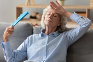 Woman cooling herself with a hand-held fan