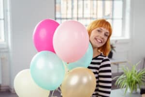 Woman holding bouquet of balloons