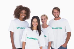 Four adults wearing volunteer T-shirts