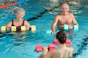 Older woman and man doing water aerobics.