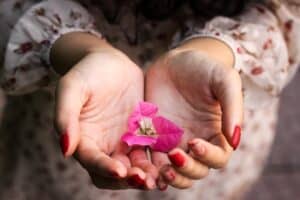 Woman holding pink flower petals in hands