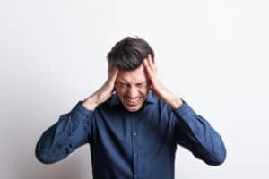 Man with tinnitus holding hands over ears