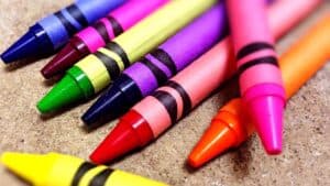8 multi-colored crayons against a tan background