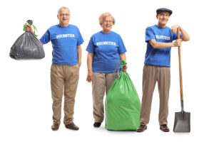 One woman and two men cleaning up litter.
