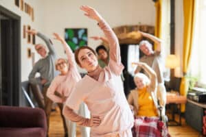Woman leading exercise class with group of seniors.