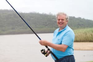 Image of smiling older man fishing.