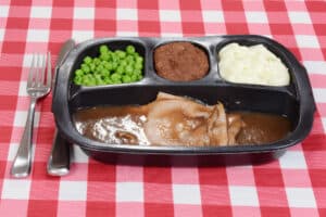 Image of TV dinner on red checkered tablecloth.