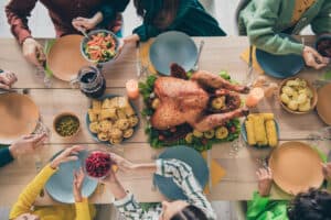 Several people gathered around a Thanksgiving meal. 