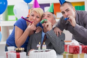 Image of two men and a woman celebrating a birthday.